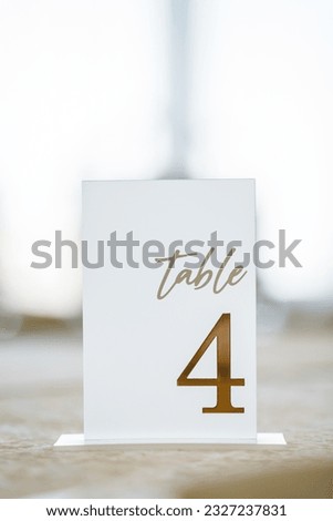 Table number 4. Setting, serving guests closeup. Stands, sign number four. Setup detail. Luxury reception. Elegant detail dinner table. Beautifully organized event. Wedding hall with atmospheric decor Royalty-Free Stock Photo #2327237831