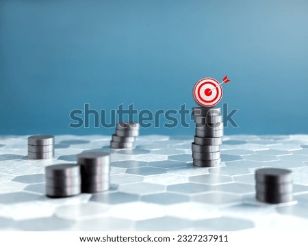 Investment target, goal management, passive income, savings and portfolio diversification concepts. 3d target icon on top of stacking coins on hexagonal grid floor and blue background with copy space.