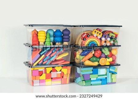 Transparent plastic containers with various children's toys on shelves. Organizing and Storage Ideas in nursery. Space organizing at childrens room. Toys sorting system. Royalty-Free Stock Photo #2327249429