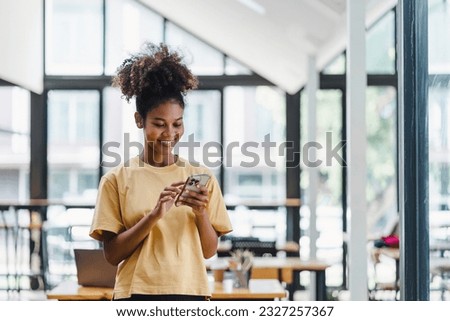 Portrait of happy young African american woman smiling confident using smartphone. afro american businesswoman reading a text message on her mobile phone