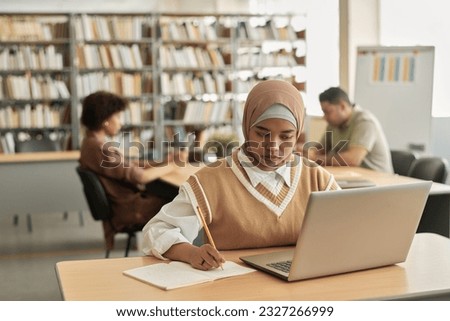 Muslim student using laptop in study