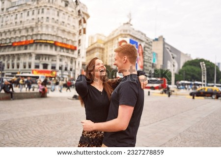 happy young adult heterosexual couple smiling hugging in the city of Buenos Aires Royalty-Free Stock Photo #2327278859