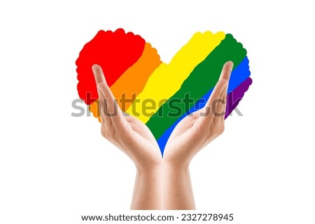 ็Hand holding rainbow heart isolated on a white background. LGBT concept.
