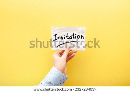 Invitation - card with text on paper note in hand on yellow background