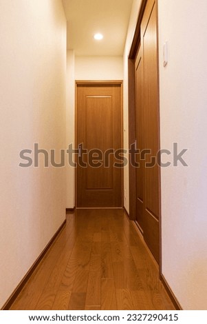 A narrow hallway with a sliding door in the back Royalty-Free Stock Photo #2327290415