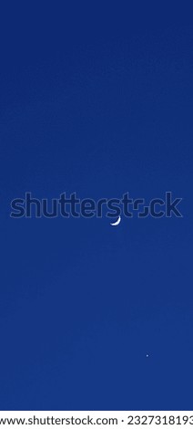 A moon captured in blue sky.