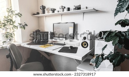 Empty modern developer workplace for writing code with computer desktop and comfy armchair Royalty-Free Stock Photo #2327318917