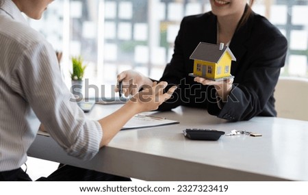 Businesswoman, real estate agent discussing the terms of the house purchase agreement contract document and letting the client sign legally, mortgage, rent, insurance.