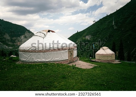 Kazakh traditional yurt in green mountains. Outdoor camping in traditional yourt concept. Travel in Kazakhstan. Royalty-Free Stock Photo #2327326561