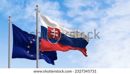 Slovakia and the European Union flags waving in the wind on a clear day. Slovakia is a member of the European Union and the Eurozone. 3d illustration render. Fluttering fabric Royalty-Free Stock Photo #2327345731