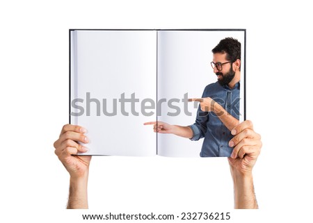Young hipster man pointing lateral printed on book