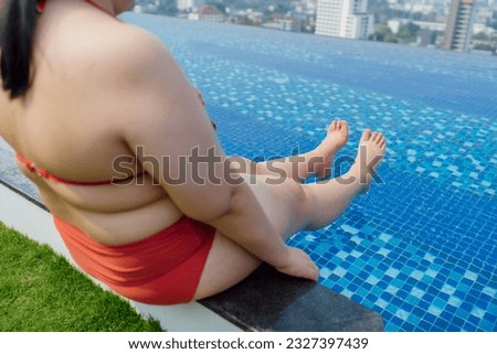 Overweight young asian woman wearing swimsuit relaxing in the pool Happy plus size woman cheery funny Vacation Traveling in summer