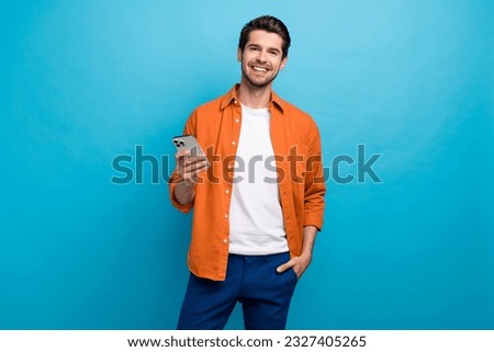 Portrait of positive nice person toothy smile hold use apple iphone texting chatting isolated on blue color background