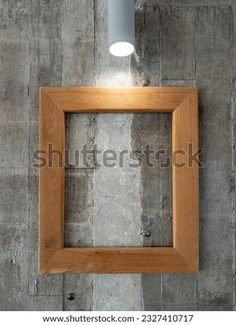 The empty wooden frame for decoration on the concrete wall in the coffee shop, front view with the copy space.