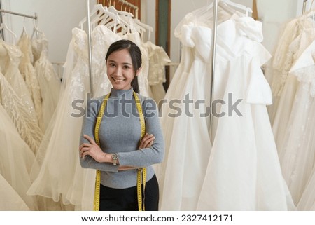 Beautiful asian woman fashion designer standing in the clothing store and studio. In front of the camera to recording vlog video live streaming.Business online influencer on social media concept. Royalty-Free Stock Photo #2327412171