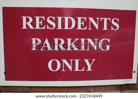 Red and white plastic sign "Residents parking only"