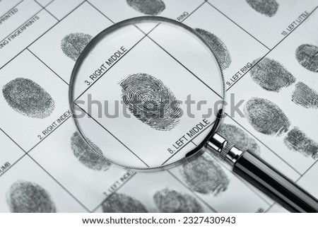 Magnifier and fingerprint police form.  Background on the theme of crime, police, detective, investigation, consequent; inquiry; inquest. Also the topic of security, identification, id, biometric etc.