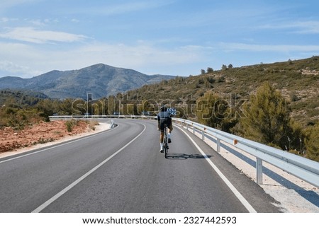 Cyclist training on road bike.Sport motivation.Cycling holiday in Spain.Man cyclist wearing cycling kit and helmet. Motivation image of an athlete. A male cyclist is cycling in the mountains