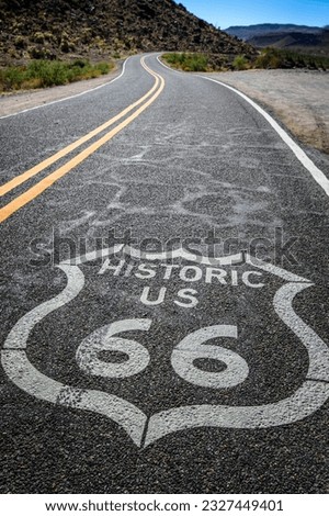 Journey through Time: Close-Up of Historic Route 66 Pavement Sign in the Mojave Desert, Embraced by Sunrise on the Black Highway Road, Presented in Exquisite 4K
