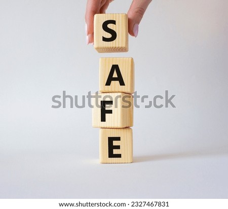 Safe symbol. Concept word Safe on wooden cubes. Businessman hand. Beautiful white background. Business and Safe concept. Copy space.