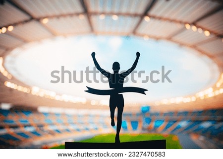 Triumph of Speed: Silhouette of Runner Soars to Victory at Modern Athletics Stadium. Edit Space, Track and Field Competition Photo.