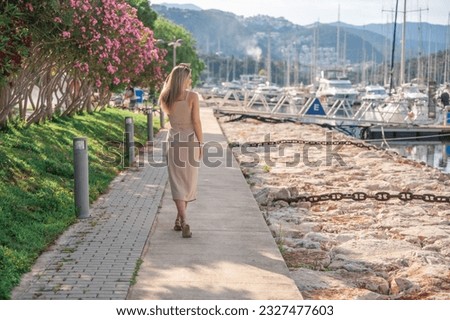 A beautiful fashion caucasian woman on luxury yachts background in marina. High quality photo