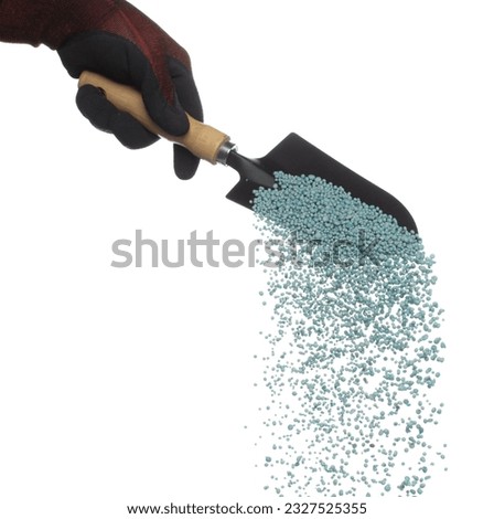 Fertilizer blue chemical accelerate growth fly fall from shovel, many tiny ball fertilizer for planting float throw in mid air. White background isolated high speed freeze motion Royalty-Free Stock Photo #2327525355