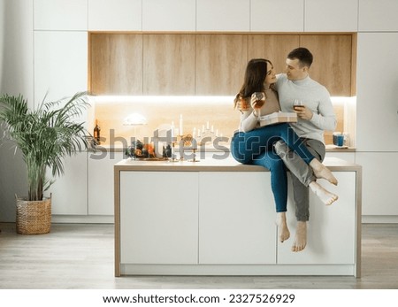 Young couple in love drinking red wine at kitchen. Cozy home. Love and romantic. Lifestyle.