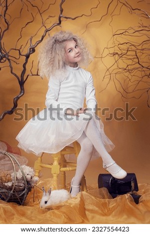 Fairytale card with a blond adorable minor girl and a white bunny. Alice in Wonderland. 