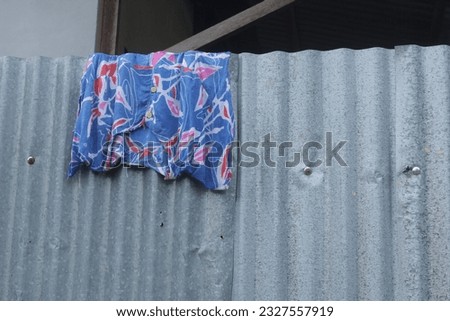 Used cloth is being dried on the zinc fence wall