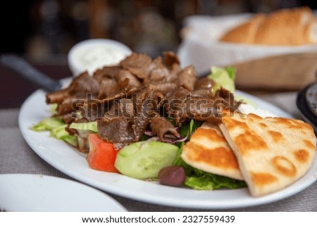 Plated Gyro Platter with salad and yogurt sauce Royalty-Free Stock Photo #2327559439