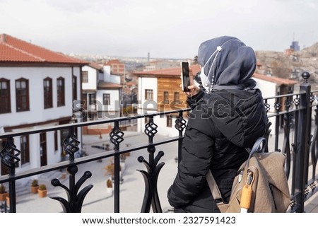 Woman taking picture on Traditional Turkish houses in Ankara, Turkey View of the historical Haci Bayram district in Ulus