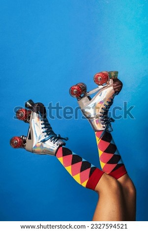 Feminine legs in a roller skates shoes with blue background