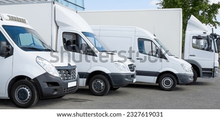 white delivery service van trucks fleet of cargo trucks courier service cars in front of factory warehouse Royalty-Free Stock Photo #2327619031