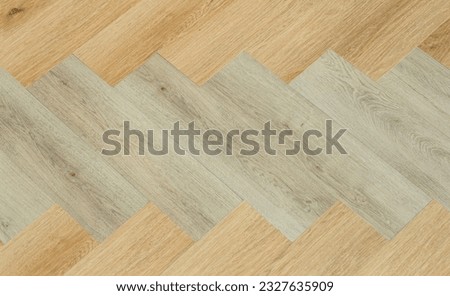 Laminate and parquet with herringbone background. Wooden floor with a chevron pattern in the living room of the designer interior