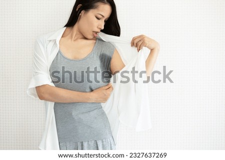 The woman is checking her armpit sweat. Royalty-Free Stock Photo #2327637269
