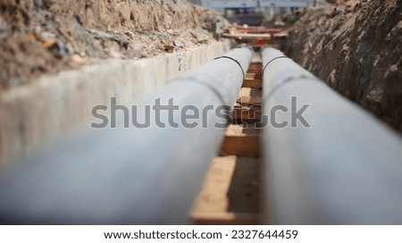 Construction and installation of the backbone pipeline of Pre-insulated hot water tubes in concrete collector.  Greening and  Efficiency of heat supply. Ongoing construction. Energy distribution. Royalty-Free Stock Photo #2327644459
