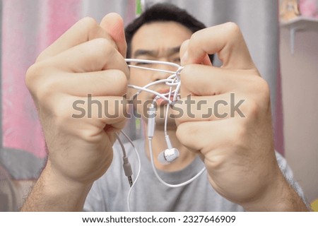 Man with tangled headphones isolated white background Royalty-Free Stock Photo #2327646909