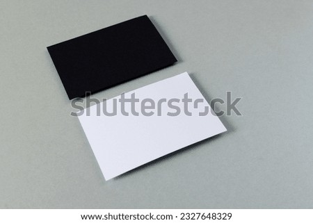 White and black business cards with copy space on grey background. Business, business card, stationery and writing space concept.