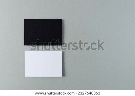 White and black business cards with copy space on grey background. Business, business card, stationery and writing space concept.
