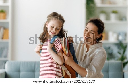 Happy family preparing for school. Little girl with mother. Royalty-Free Stock Photo #2327659179