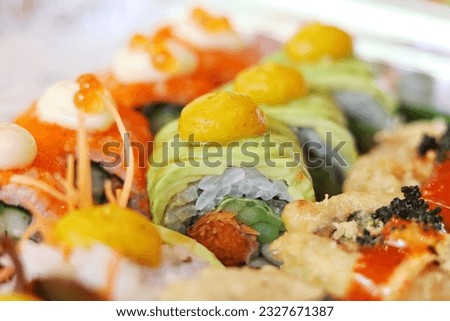 Closeup avocado sushi roll with pumpkin sauce 