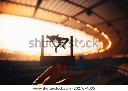 Silhouette of High Jumper Soaring against Twilight Sky. Photo for Summer Games  in Paris. Edit Space for Your Montage Royalty-Free Stock Photo #2327674035