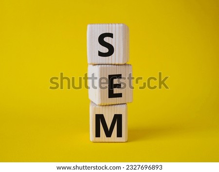 SEM - Search Engine Marketing symbol. Wooden cubes with words SEM. Beautiful yellow background. Business and SEM concept. Copy space.
