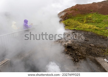 Tourists taking pictures at steaming hot sulfur springs of Seltun Geothermal Area, Krysuvik, Reykjanes Peninsula in Iceland