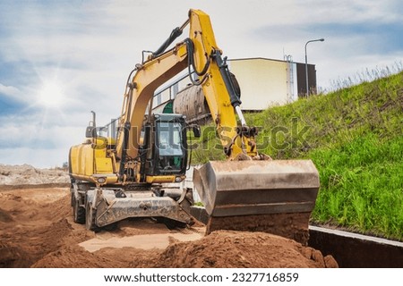 A powerful wheeled excavator prepares the site for the construction of the railway. Excavator with a wide bucket leveling the surface of the railway track. Excavation Royalty-Free Stock Photo #2327716859