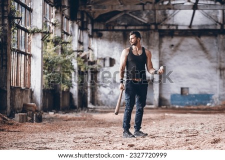 Strong Muscular Handsome Man in Black Tank Top with Baseball Bat in Empty Grunge Hall