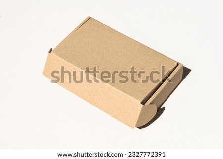 Rectangular closed box made of corrugated cardboard on a white background. Top view of a cartoon highlighted on a white background with a clipping outline. Brown cardboard box for delivery. Royalty-Free Stock Photo #2327772391