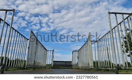 Flanked by iron cages, doors open to a vast, beautiful blue sky. 
