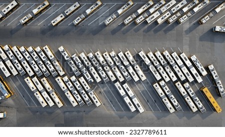 Aerial top down shot of bus terminus, designated place where bus or coach starts or ends its scheduled route termini, buses in parking lot. Royalty-Free Stock Photo #2327789611
